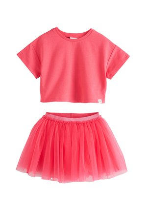 Jasnoružový krátky crop top s krátkymi rukávmi, v páre so zodpovedajúcou ružovou tylovou sukňou s elastickým pásom.