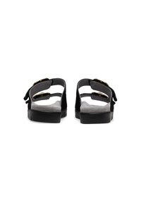 Black sandals with two adjustable straps featuring gold buckles. Soft suede-like material and textured black soles, designed for comfort.