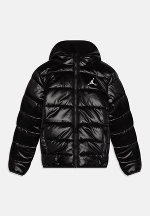 Chaqueta negra acolchada brillante con capucha, cremallera frontal, dos bolsillos laterales y logo Jumpman blanco en el pecho izquierdo.