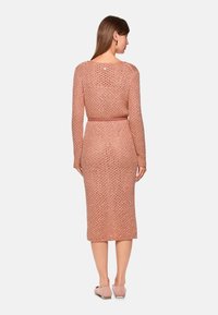 Langärmeliges, gestricktes Kleid in Rosé mit offenem Muster, figurbetonter Silhouette und passendem Gürtel. Glatte Textur; knielang.