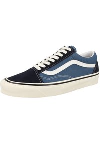 Blue and navy canvas sneaker with white accents, black stripe on midsole, and white laces; features round toe and textured surface.