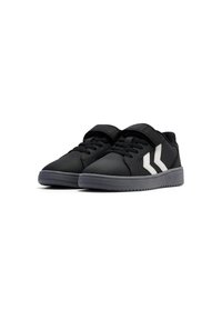 Svarta sneakers med en slät syntetisk ovandel, platt grå sula och kontrasterande vita ränder på sidorna. Har snören och ett kardborreband.