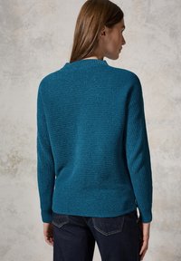 Türkisfarbener gerippter Pullover mit weitem Kragen und langen Ärmeln, hergestellt aus strukturiertem Strickstoff; zeichnet sich durch eine lockere Passform und seitliche Schlitze am Saum aus.