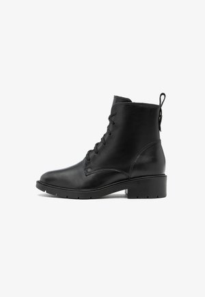 Bottines en cuir noir avec un laçage à l'avant, bout rond et petit talon carré. Elles disposent d'une languette à l'arrière et de coutures latérales discrètes.