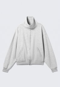 Világosszürke cipzáros pulóver magas gallérral, oldalzsebekkel és bordázott mandzsettákkal. Puha anyagból készült, kényelmes szabással és enyhén túlméretezett kialakítással.