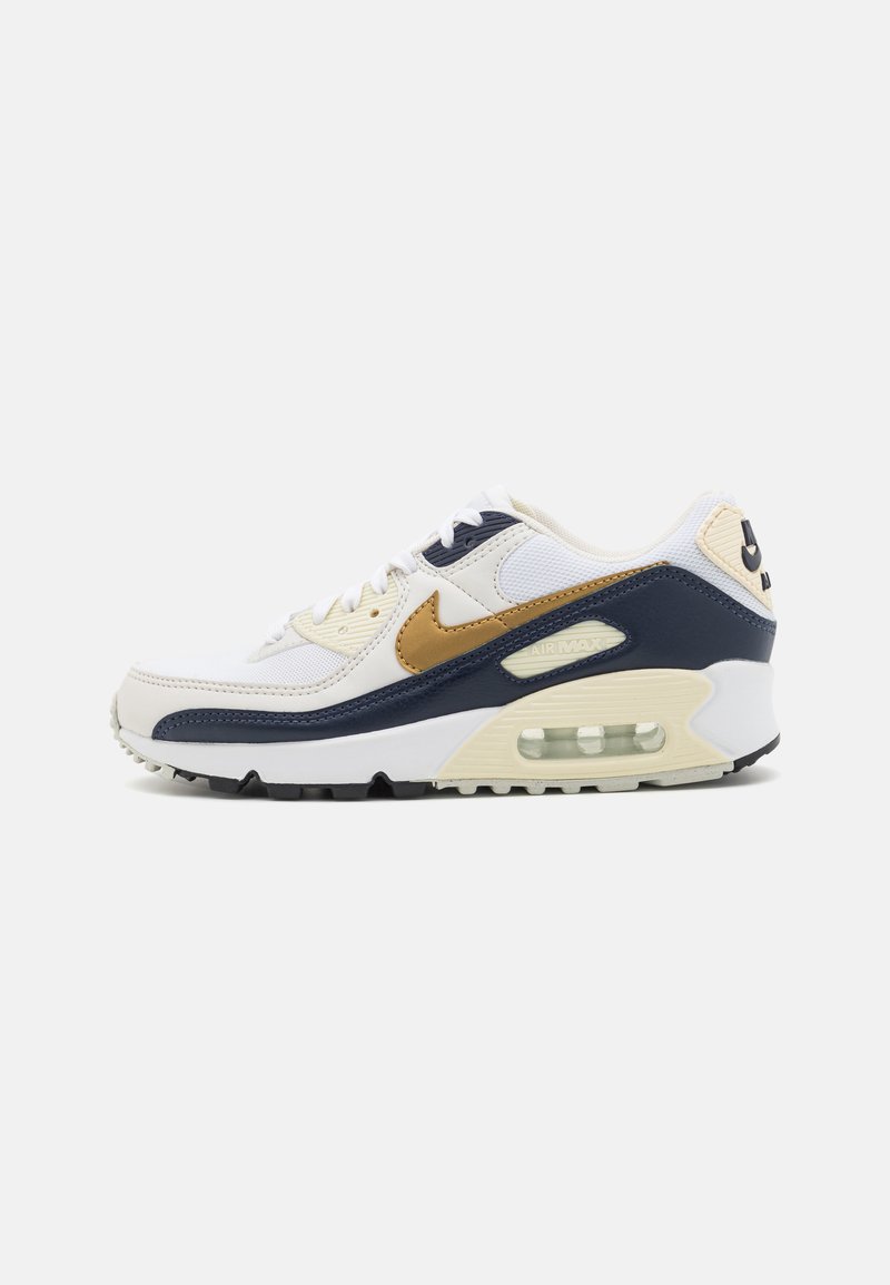 Zapatilla Nike Air Max en blanco, azul marino y dorado con suela de cojín de aire visible, diseño de cordones y logotipo en el costado y el talón, vista lateral.