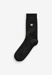 Black cotton sock with a smooth texture featuring a small green character logo near the top. Simple, classic design for casual wear.