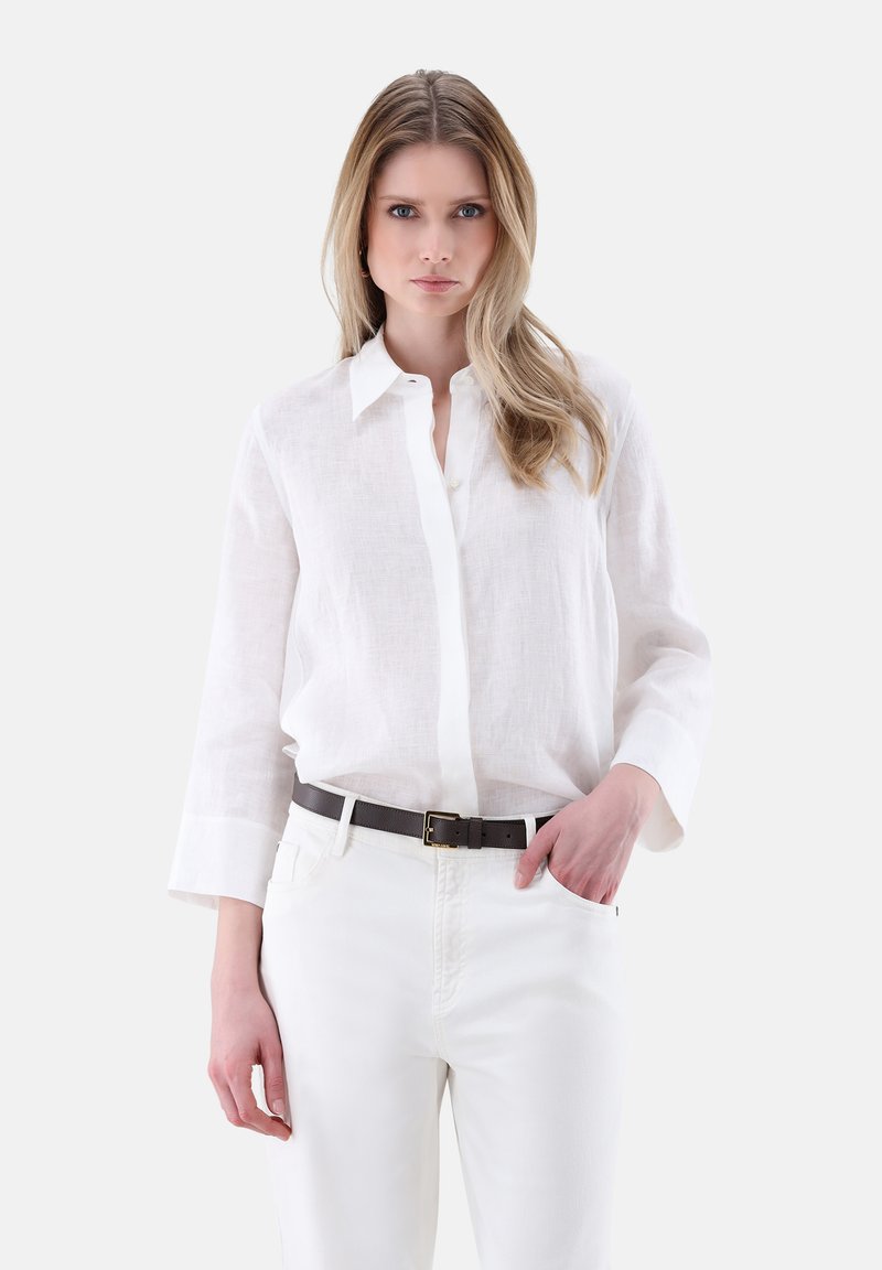 White linen button-up shirt with long sleeves, paired with white pants and a dark brown leather belt with a gold buckle.