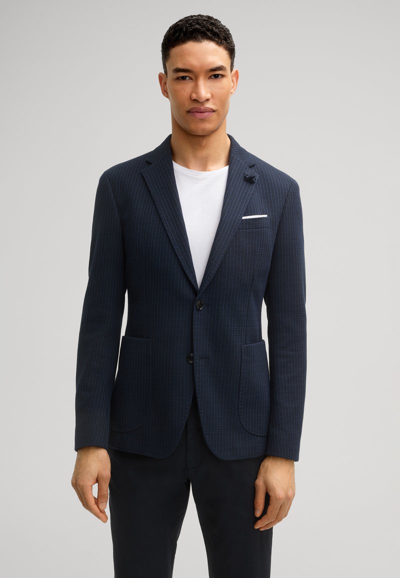 Marine gestreepte blazer in gestructureerde stof, met twee voorzakken, een enkele knoopsluiting en een subtiele pochetdetail.