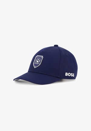 Casquette de baseball bleu marine avec une couronne arrondie, une visière courbée, un emblème circulaire représentant un ballon de football, et le logo 'BOSS' en blanc sur le côté.