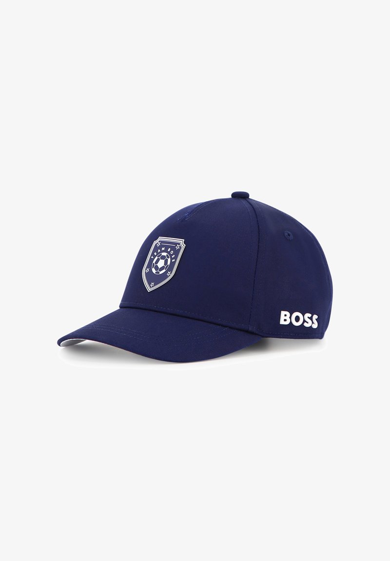 Casquette de baseball bleu marine avec une couronne arrondie, une visière courbée, un emblème circulaire représentant un ballon de football, et le logo 'BOSS' en blanc sur le côté.