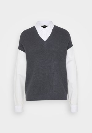 Sivi pleteni pulover s V-izrezom, kratkim rukavima i bijelom košuljom ispod. Glatka tekstura, ležeran dizajn.