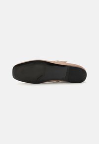 Brown leather shoe sole with a flat black rubber outsole and textured detailing. Features a logo on the side and a rounded shape.