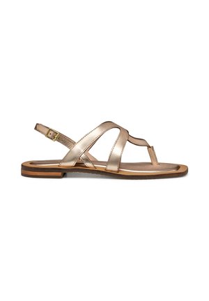 Sandalo piatto in oro rosa metallico con cinturini incrociati e fibbia regolabile alla caviglia su suola marrone.