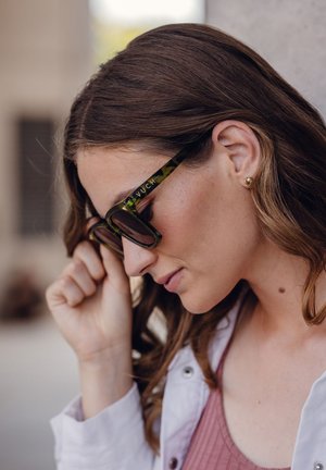 Green marbled sunglasses with a thick frame, featuring a subtle logo on the side. The lenses are dark, complementing the textured design.