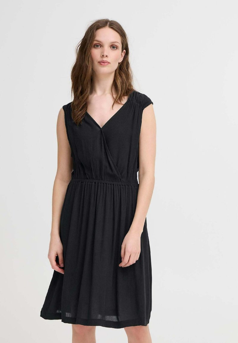 Rochie neagră fără mâneci, cu decolteu în V, detalii pliate la umeri și talie elasticizată. Siluetă în forma literei A, fabricată dintr-un material texturat.