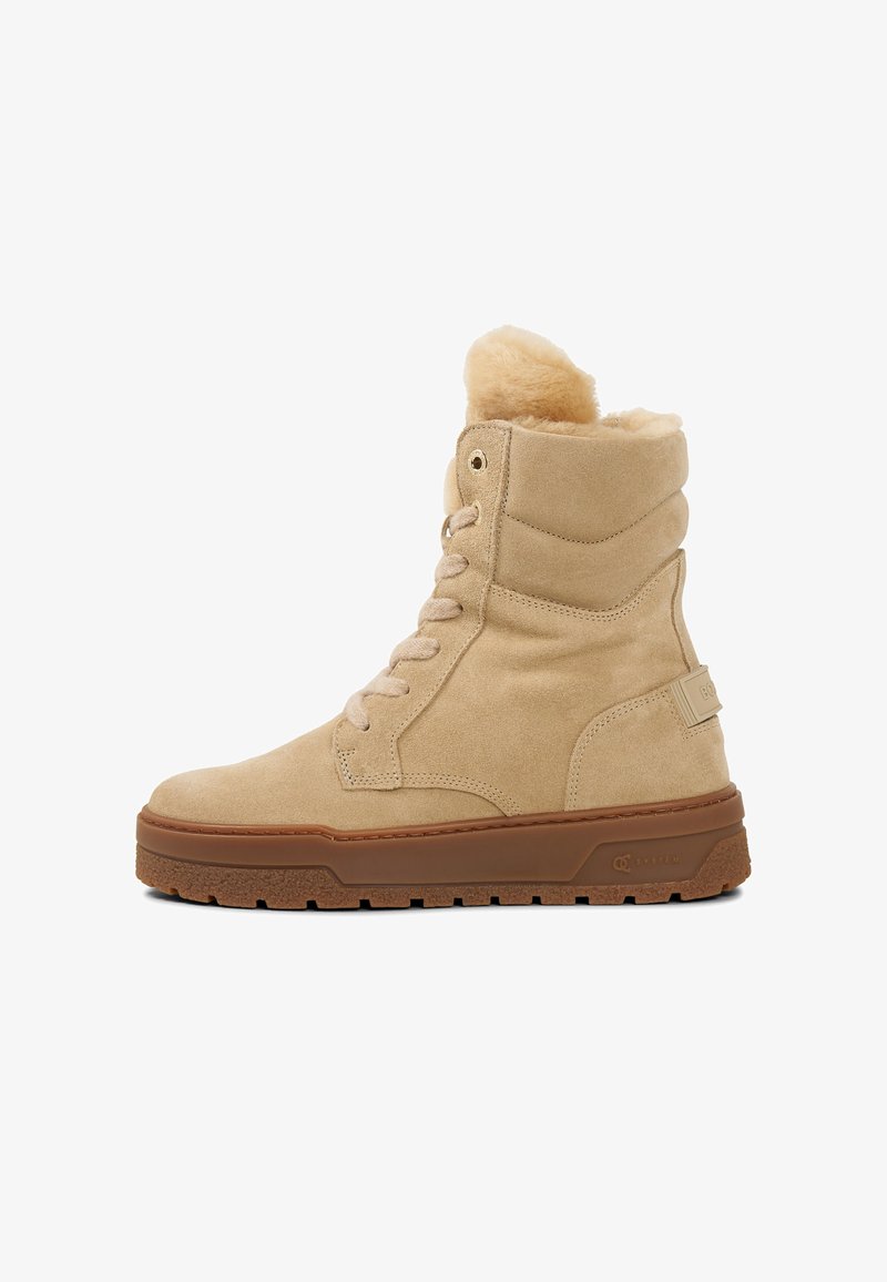 Béžové semišové vysoké boty s měkkou chlupatou podšívkou, kulatou špičkou, zavazováním na tkaničky a hnědou gumovou podrážkou s texturovaným gripem.
