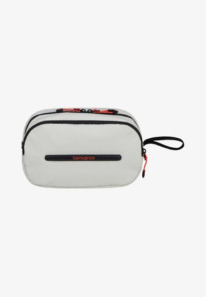 Samsonite travel pouch in textured white fabric, featuring two zippers with black trim and red accents, plus a side handle for easy carrying.