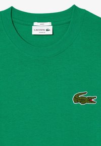 Grøn bomulds t-shirt med rund hals, med et broderet, multicolor krokodille-logo på venstre bryst. L�øs pasform.