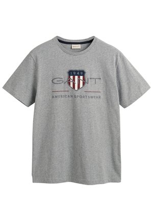 Graues T-Shirt mit Rundhalsausschnitt und dem "GANT"-Logo, einem Schildemblem mit "1949" sowie dem Schriftzug "American Sportswear" in der vorderen Mitte.
