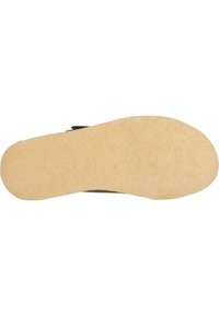 Svart sko sula med texturerad yta, böjd form och ljusfärgad gummibotten. Slät kontur utan distinkta mönster eller detaljer.