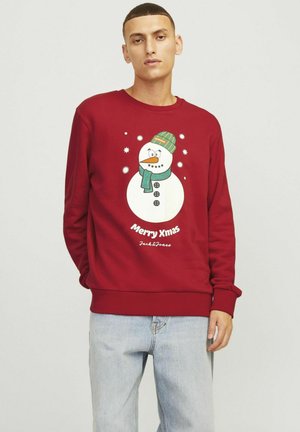 Sweatshirt rouge avec un graphique de bonhomme de neige portant un chapeau et une écharpe verts. Le texte "Joyeux Noël" est écrit en dessous du bonhomme de neige. Coupe standard.