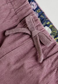 Svetlofialové kordové šortky s textúrovaným povrchom, vybavené látkovým viazaním v oblasti pásu a kvetinovým vzorom na vnútornej podšívke.