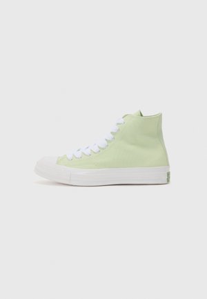 Lichtgroene hoge canvas sneaker met witte rubberen zool en witte veters, vanaf de zijkant getoond op een witte achtergrond.