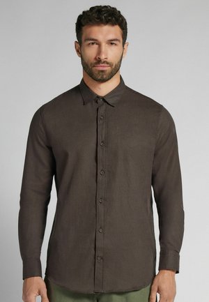 Brown long-sleeve shirt with a button-down collar, crafted from textured fabric. Features front buttons and a hem that curves upwards at the sides.