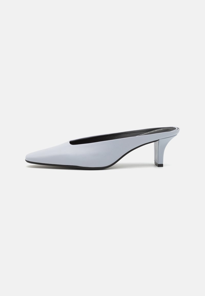 Mule en cuir verni bleu clair avec un orteil pointu, un petit talon transparent et un design épuré mettant en valeur une découpe au cou-de-pied.