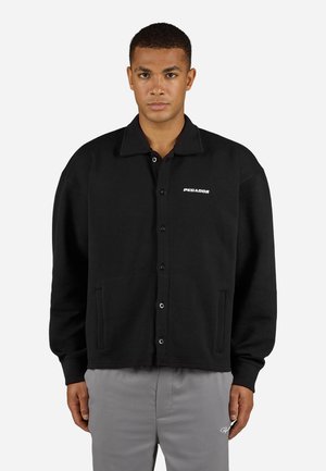 Black button-up jacket with a textured pattern, a flat collar, and two side pockets. Features a white logo on the left chest area.