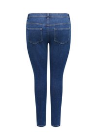 Jean en denim bleu foncé avec deux poches arrière, jambes droites et coutures visibles sur les coutures et les poches.