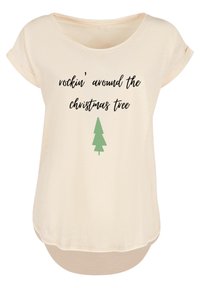 Cremefarbenes T-Shirt mit aufgerollten Ärmeln und abgerundetem Saum. Mit schwarzem Text "rockin' around the christmas tree" und einer grünen Tannenbaum-Grafik.