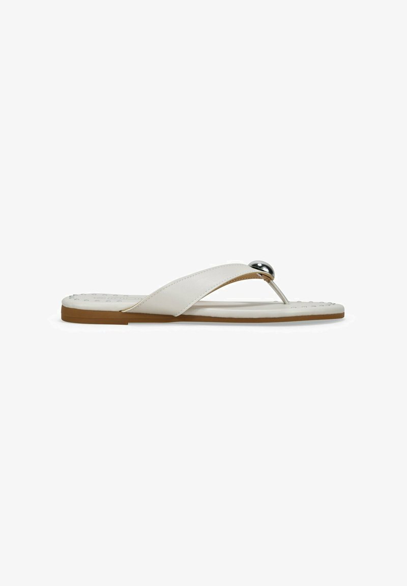 Sandalias blancas de tipo flip-flop con upper de cuero suave, un elegante acento metálico, suela plana de goma marrón y plantilla texturada para mayor comodidad.