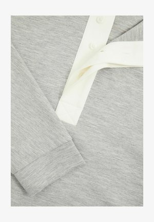Grau langärmliges Shirt aus strukturiertem Stoff, mit einer hellen Knopfleiste und kontrastierenden weißen Kragenakzenten.