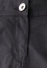 Pantaloni di tessuto nero con una texture liscia, caratterizzati da un bottone metallico argento e cuciture dettagliate lungo le cuciture.