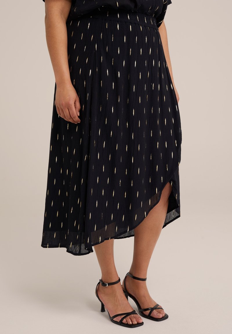 Keskisininen midi-hame, jossa on kultaiset nuoliin muistuttavat kuviot, suihkuava kangas, epäsymmetrinen helma ja etureikä, yhdistettynä mustiin remmikenkiin.