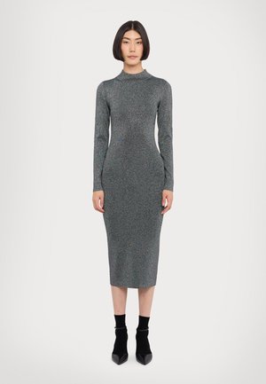 Body-hugging, long-sleeve dress in textured, glittery gray fabric. Features a high neckline and a midi length, with black pointed boots.