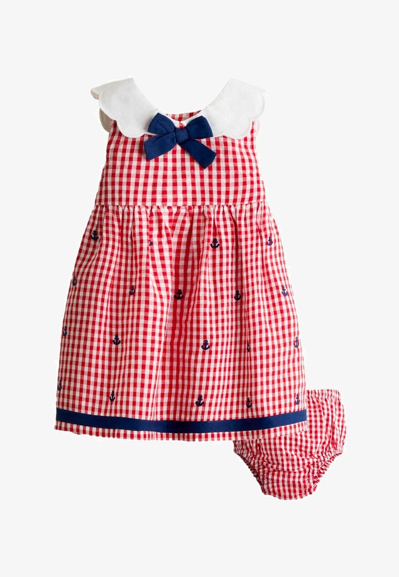 Vestitino da bambino in gingham rosso e bianco con ancore blu navy, colletto bianco smerlato, fiocco blu navy e copripannolino abbinato.