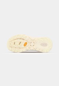 Semelle de chaussure en crème clair avec une surface texturée ; présente des rainures profondes et un logo orange ; conçue pour l'adhérence et la stabilité.