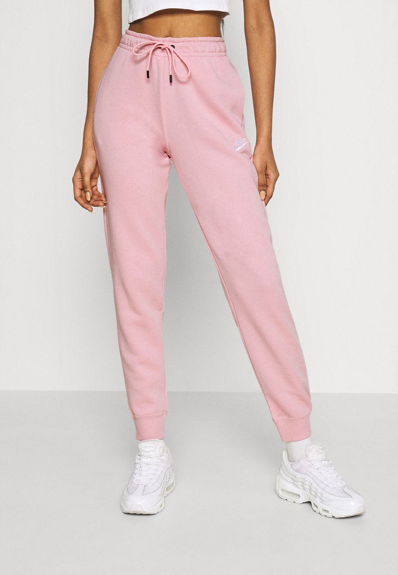 Light pink sweatpants with a drawstring waistband, tapered legs, elastic cuffs, and a small white logo on the left thigh.