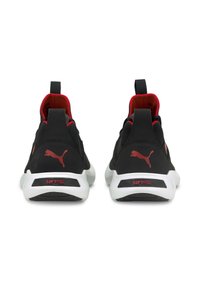 Chaussures de sport noires avec une tige texturée, des accents rouges sur le col et une semelle intermédiaire blanche portant la marque "SOFTRIDE" au talon.