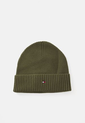 Gebreide olijfgroene beanie met een geribde boord en een klein logo-opdruk met rode, witte en blauwe accenten. Zachte textuur en een aansluitende vorm.