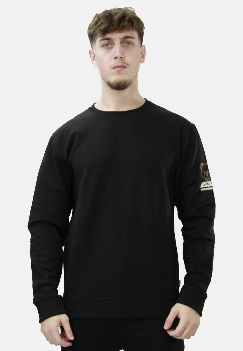 Felpa nera a collo rotondo con maniche lunghe. Presenta un logo di un orso sulla manica destra e un bordo e polsini a coste. Texture del tessuto morbida.