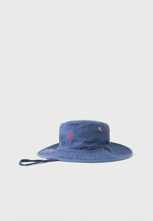 Chapeau bob bleu à large bord avec œillets de ventilation et sangle réglable sous le menton, avec un petit logo rouge brodé sur le côté.
