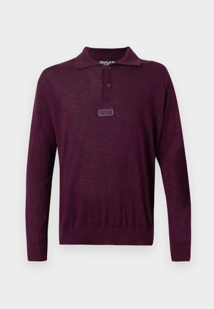Burgunderfarget strikket polo skjorte med lange ermer, knappet krage og merket lapp på fronten. Diskret shimmer tekstur gjennom hele.