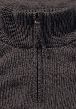 Koolgrijs gebreid pullover met hoge kraag en korte rits. Heeft een geribbelde textuur en een contrasterende ritslus.