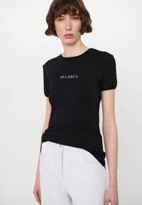 Black short-sleeve t-shirt with a round neckline featuring white "MAX&Co." text. Smooth cotton material, fitted shape, minimalist design.