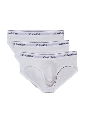 Drei Paare von weißen Baumwollslips mit einem grauen und schwarzen Calvin Klein-Logo am elastischen Bund, das eine glatte Textur und einen klassischen Schnitt aufweist.