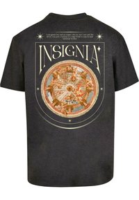 Juodas medvilnės marškinėliai su apvaliu grafiniu dizainu, vaizduojančiu cherubus ir išraiškingus ornamentus, viršuje esantis užrašas "INSIGNIA" dekoratyviu šriftu.
